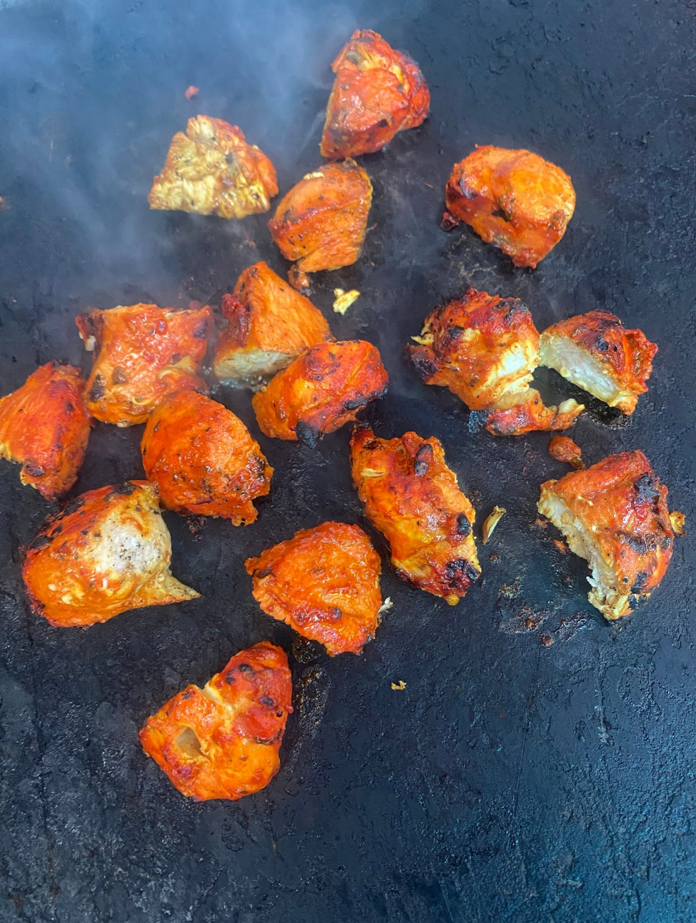 Grilled tandoori chicken pieces on the grill at Sunny's Fish Bar